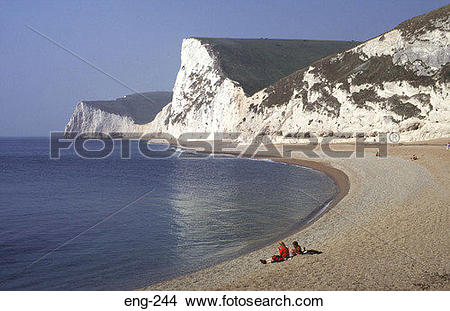 Stock Photo of People Sitting under Chalk Cliffs Dorset England.