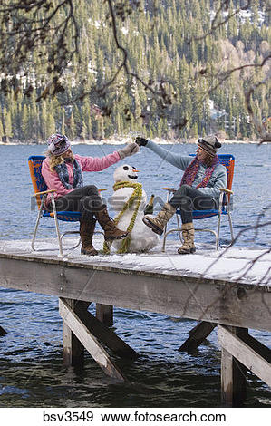 Stock Photograph of Two women friends drinking champagne on a dock.