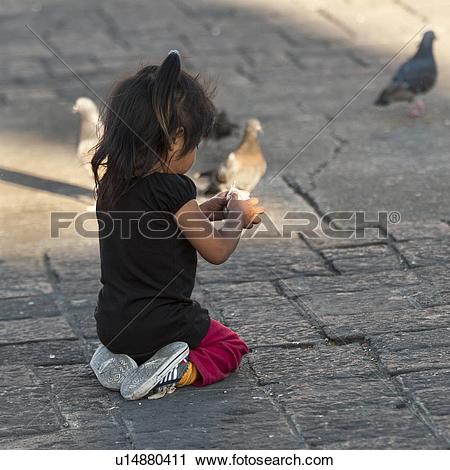 Stock Photography of Girl feeding pigeons, Parque Central, Zona 1.