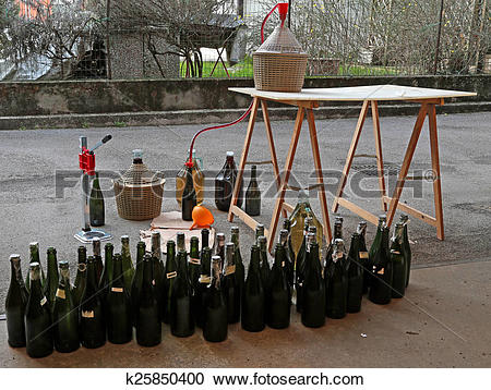 Stock Photography of pour red wine from the demijohn to bottles.