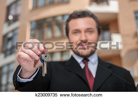 Stock Image of closeup on adult man holding key to dream house.