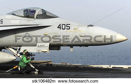 Stock Photo of An aviation boatswain's mate guides an F/A.