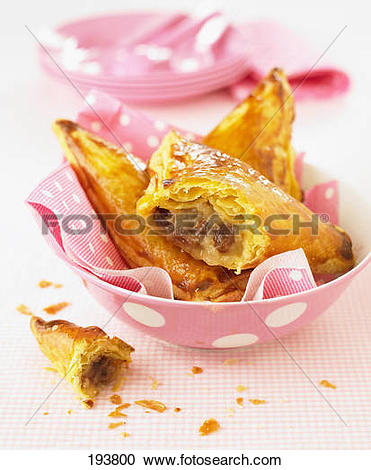 Stock Photography of Stewed apple and raisin flaky pastry pies.