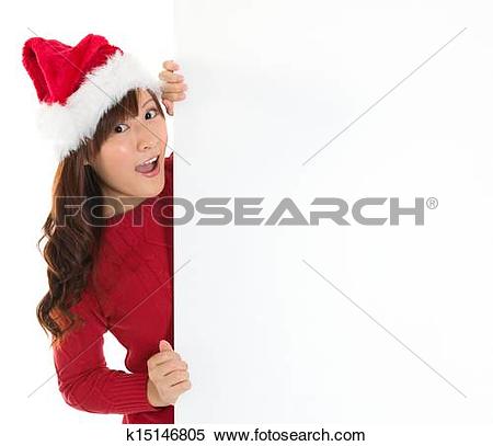 Stock Image of Santa girl peeking from behind blank sign billboard.