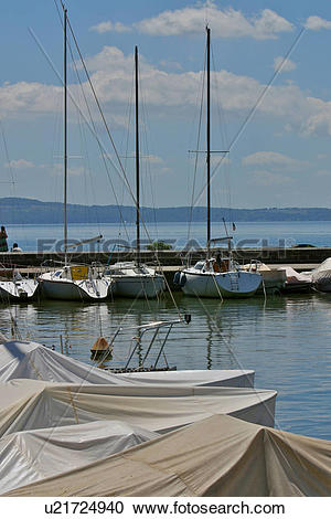 Stock Photography of Yachts in harbour, with jetty beyond, blue.