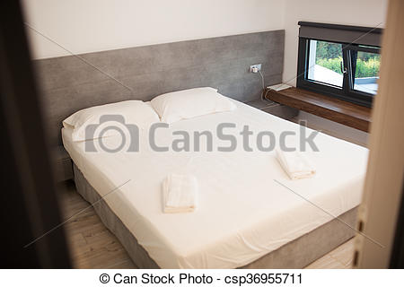 Stock Photography of Empty hotel room for two with matrimonial bed.