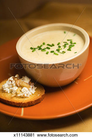Stock Photography of Bowl of parsnip soup and crostini with cheese.
