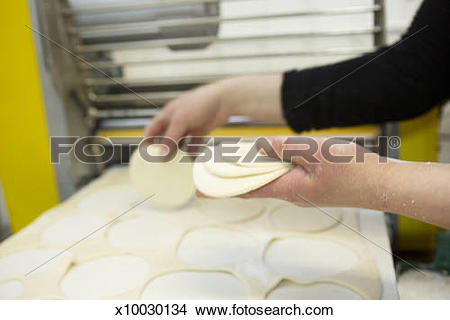 Stock Photo of Pastry chef picking up cut pieces of pastry.