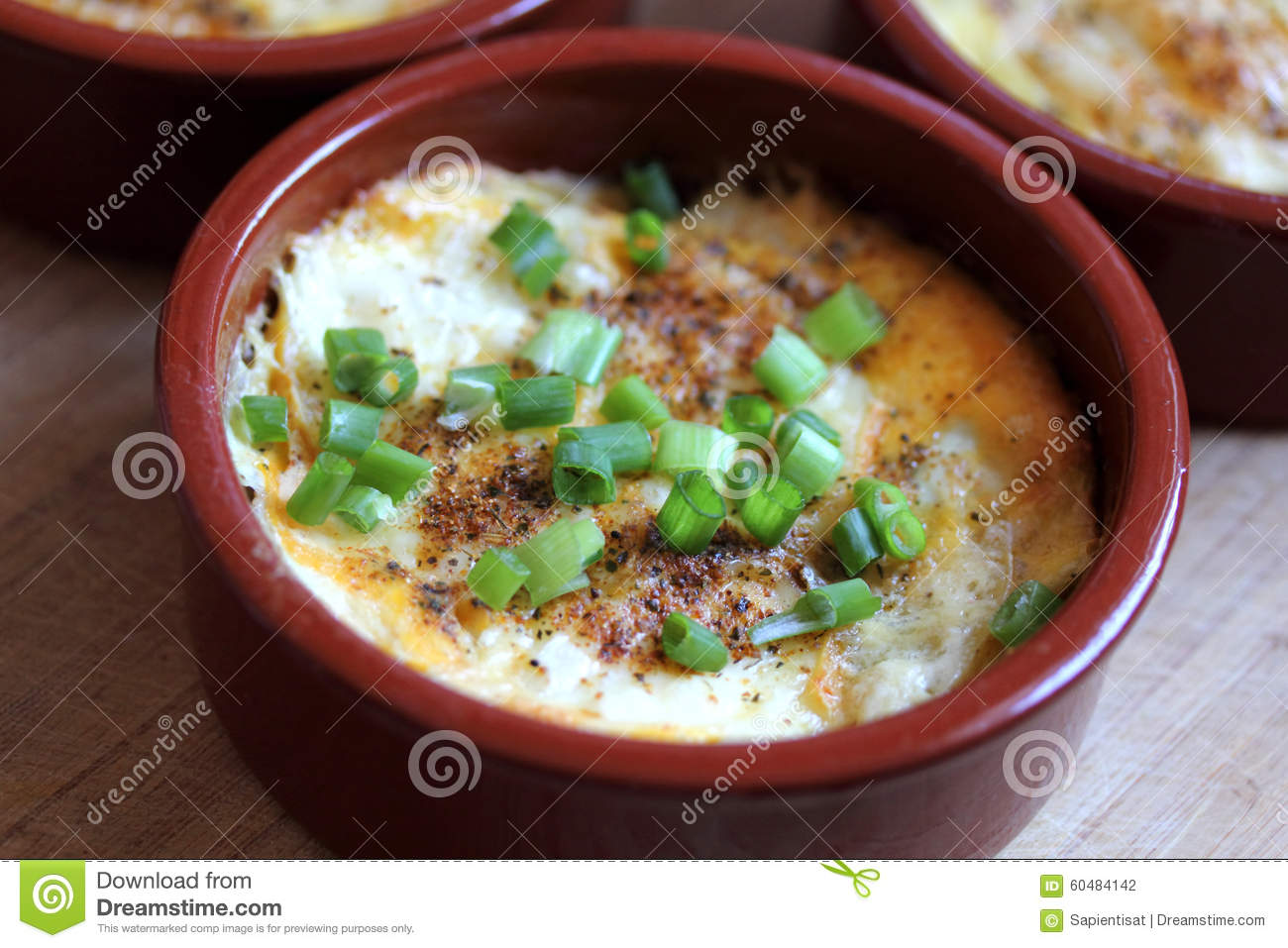 Potato Gratin Baked In A Small Ceramic Dish With A Rustic Setting.