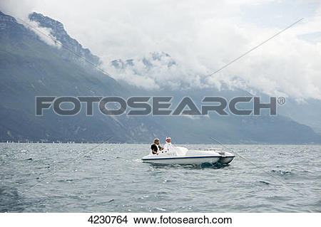 Stock Photo of Senior couple with pedal boat in mountain scenery.