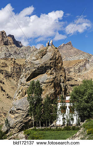 Picture of Buddha statue on rock formations in remote landscape.