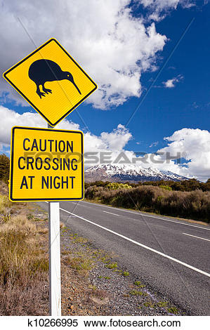 Stock Image of Kiwi Crossing road sign and volcano Ruapehu NZ.