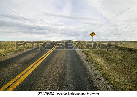 Stock Photo of An empty highway with a sign indicating a curve up.