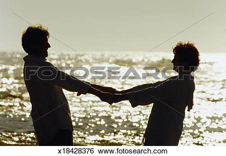 Stock Images of Silhouette side view of senior couple holding.
