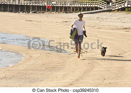 Stock Photography of man walking with the dog on the beach. Summer.