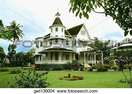 Stock Photo of Side view of a stately mansion with a lawn in front.