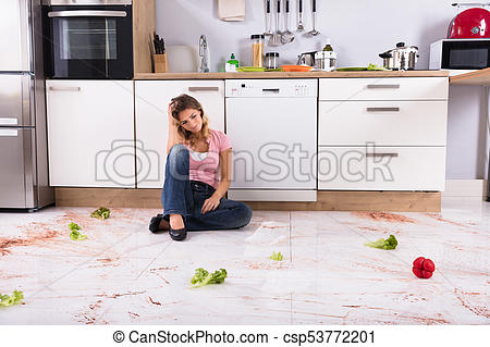 Woman Sitting On Messy Kitchen Floor.